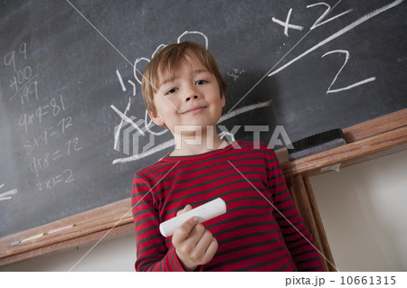 Schoolboy writing on blackboard 10661315
