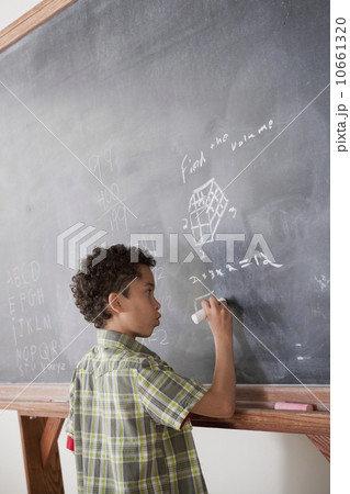Schoolboy writing on blackboard Schoolboy writing on blackboard 10661320
