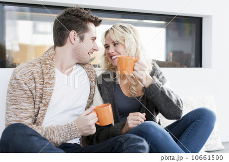 Couple drinking coffee in front of fireplace Couple drinking coffee in front of fireplace 10661590