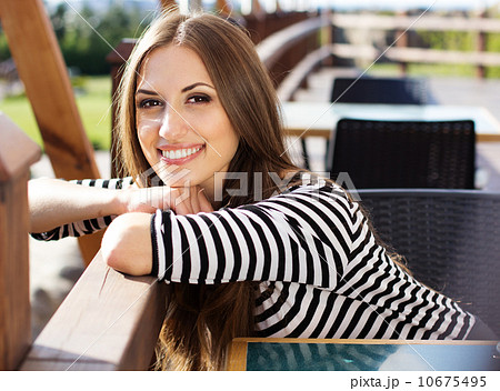 Young woman drinking coffee in a cafe outdoors 10675495