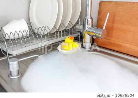 yellow rubber duck in foamy kitchen sink 10676504