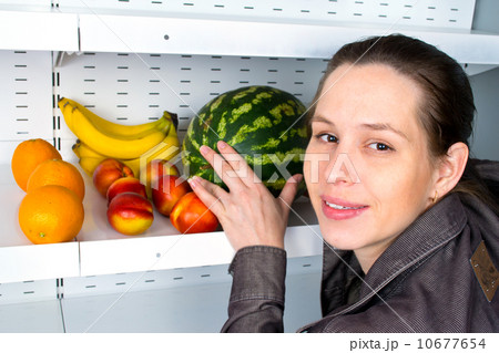Image of a woman buying fruits in a market. 10677654