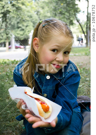 The girl eats hotdog 10678752