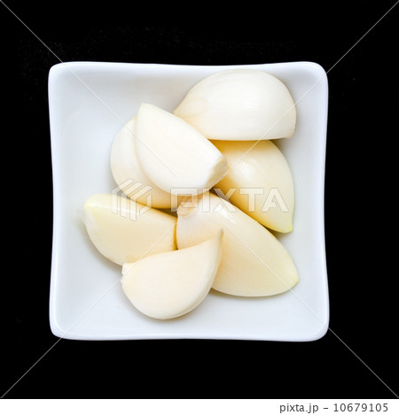 Garlic in a glass white plate on black background 10679105