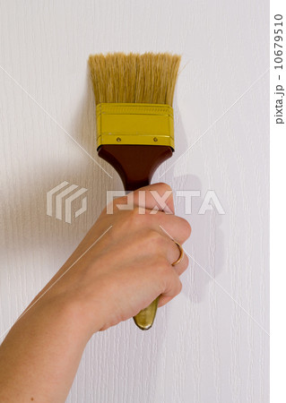 The hand paints with a brush a wall 10679510
