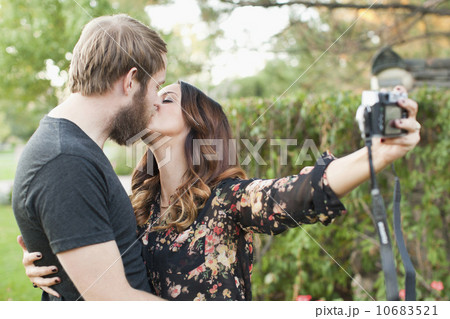 Couple taking picture while kissing 10683521