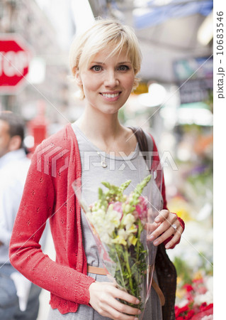 Portrait of smiling woman holding bunch of flowers 10683546