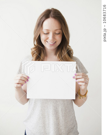 Portrait of cheerful young woman holding blank card 10683716