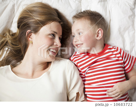 Mother and toddler boy (2-3) lying in bed  10683722