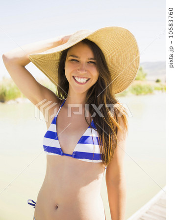 Portrait of young woman wearing sun hat on beach 10683760