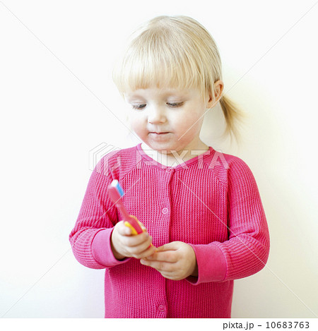 Studio shot of girl (2-3) holding toothbrush 10683763