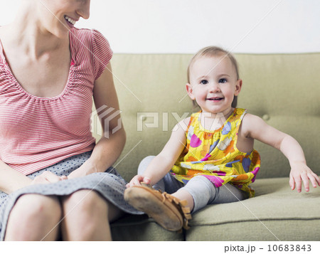 Mother with daughter (12-17 months) sitting on sofa Mother with daughter (12-17 months) sitting on sofa 10683843