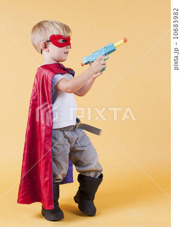 Studio shot, Portrait of boy (2-5 years) wearing cape and holding toy gun 10683982
