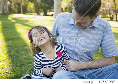 Father tickling his daughter (4-5 years) on sunny day in park Father tickling his daughter (4-5 years) on sunny day in park 10683997
