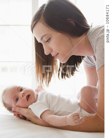 Mother changing baby girl (2-5 months) 10684171
