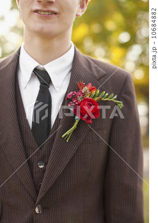 Mid section of groom wearing full suit decorated with boutonniere 10684882