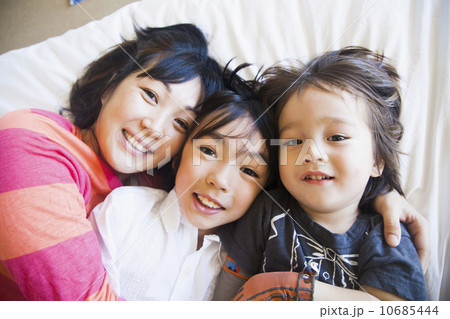 Mother with children cuddling on bed 10685444