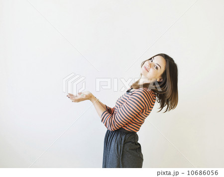 Studio shot young woman bending over backwards pretending like holding something Studio shot young woman bending over backwards pretending like holding something 10686056