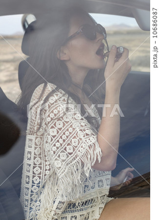 Fuerteventura, Spain, Woman in car applying lipstick  10686087