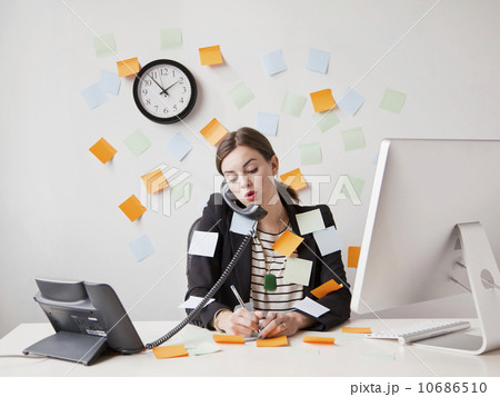 Studio shot of young woman working in office covered with adhesive notes 10686510