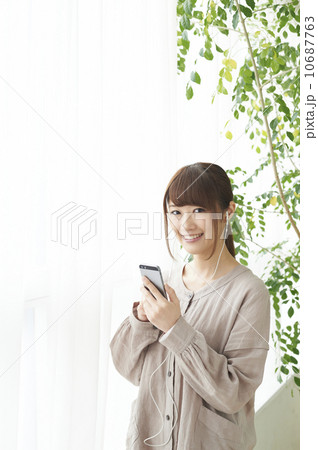 スマートフォンで音楽鑑賞する女性 10687763