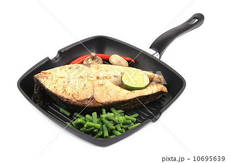 Frying pan with salmon steak, veggies and lime. 10695639