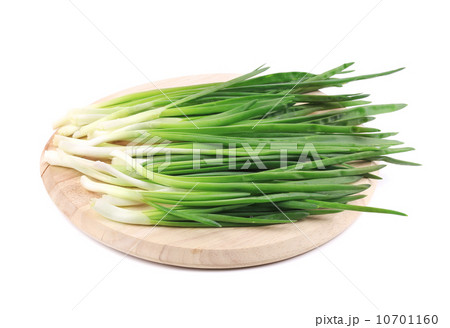 Bunch of green onion on wooden platter. 10701160