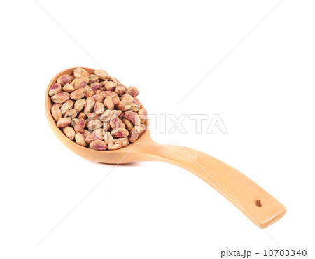 Wooden spoon with peeled pistachios. Wooden spoon with peeled pistachios. 10703340