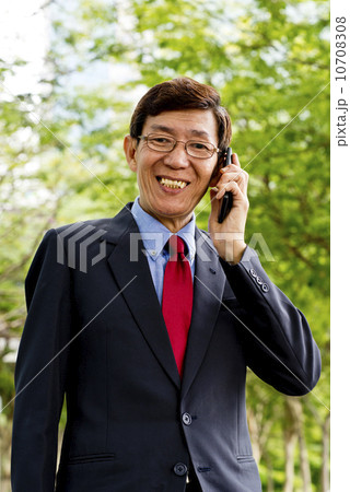 Asian businessman with mobile phone at the park Asian businessman with mobile phone at the park 10708308