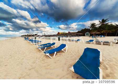 sun loungers on sandy beach 10709596