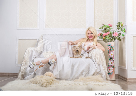 Luxurious blonde woman in a white dress with a dog  pekingese 10713519