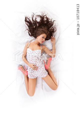 Portrait of beautiful young woman lying in bed 10718413
