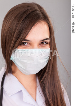 Doctor / nurse smiling behind surgeon mask. Closeup portrait of 10718515