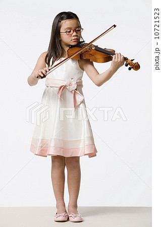 Girl (8-9) playing violin, studio shot Girl (8-9) playing violin, studio shot 10721523