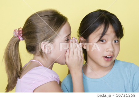 Studio portrait of teenage (16-17) girls gossiping 10721558