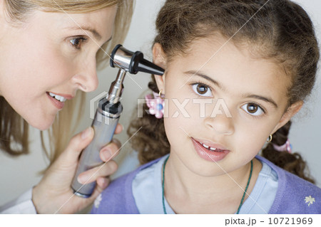Doctor examining girl's (10-11) ear Doctor examining girl's (10-11) ear 10721969