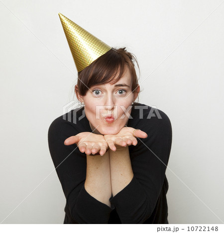 Studio Shot of young woman party hat blowing kiss Studio Shot of young woman party hat blowing kiss 10722148