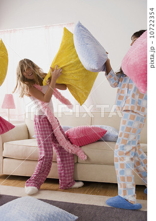 Two girls (10-11) having pillow fight at slumber party 10722354