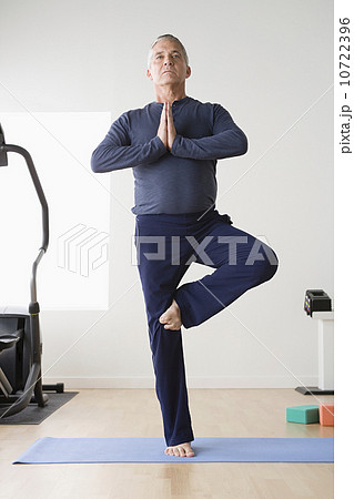 Mature man practicing yoga on mat 10722396