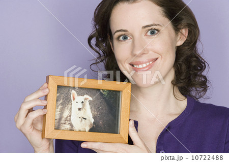 Portrait of mid adult woman holding picture of her dog Portrait of mid adult woman holding picture of her dog 10722488