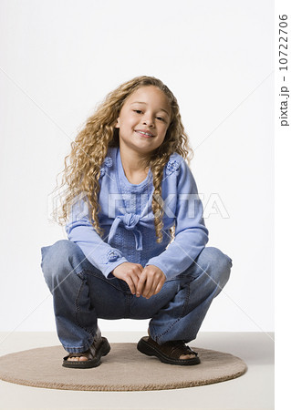 Portrait of smiling girl (8-9 crouching), studio shot Portrait of smiling girl (8-9 crouching), studio shot 10722706
