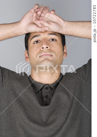 Studio shot portrait of mid adult man with arms raised, head and shoulders Studio shot portrait of mid adult man with arms raised, head and shoulders 10722785