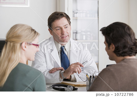 Male doctor talking to patients in his office Male doctor talking to patients in his office 10722786