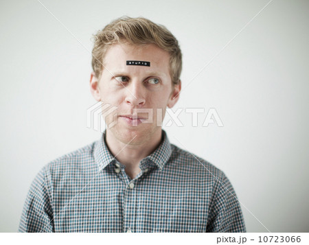 Studio shot of young man with black concept label on forehead 10723066