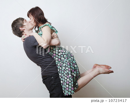Happy young couple kissing in studio 10723417
