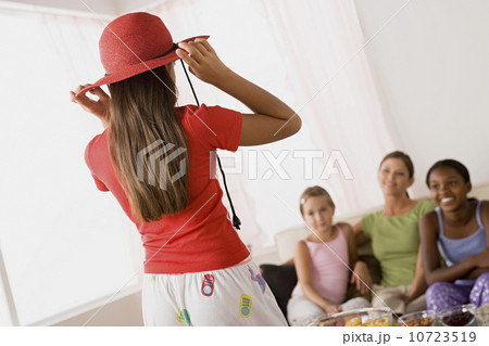 Three girls (10-11) and woman playing at slumber party Three girls (10-11) and woman playing at slumber party 10723519