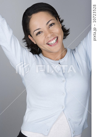 Studio shot portrait of mid adult woman with arms raised, waist up 10723528