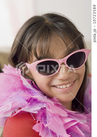 Portrait of smiling girl (10-11) wearing feather boa and sunglasses 10723589