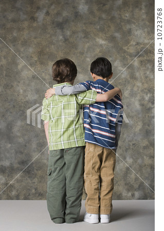Rear view of two boys (6-7, 8-9) standing together, studio shot 10723768
