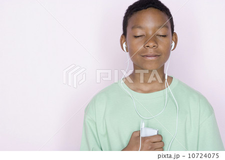 Studio portrait of teenage boy listening to music Studio portrait of teenage boy listening to music 10724075